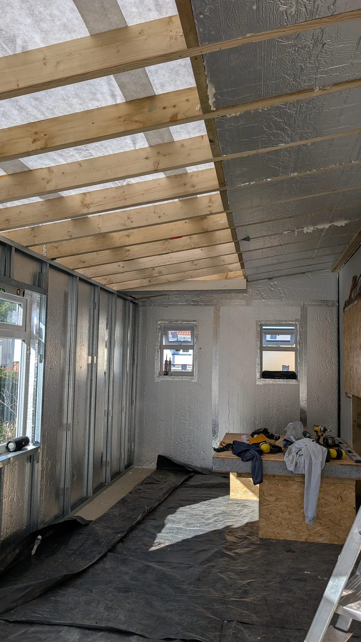 Continuous foil-faced insulation and lightweight wall framing
