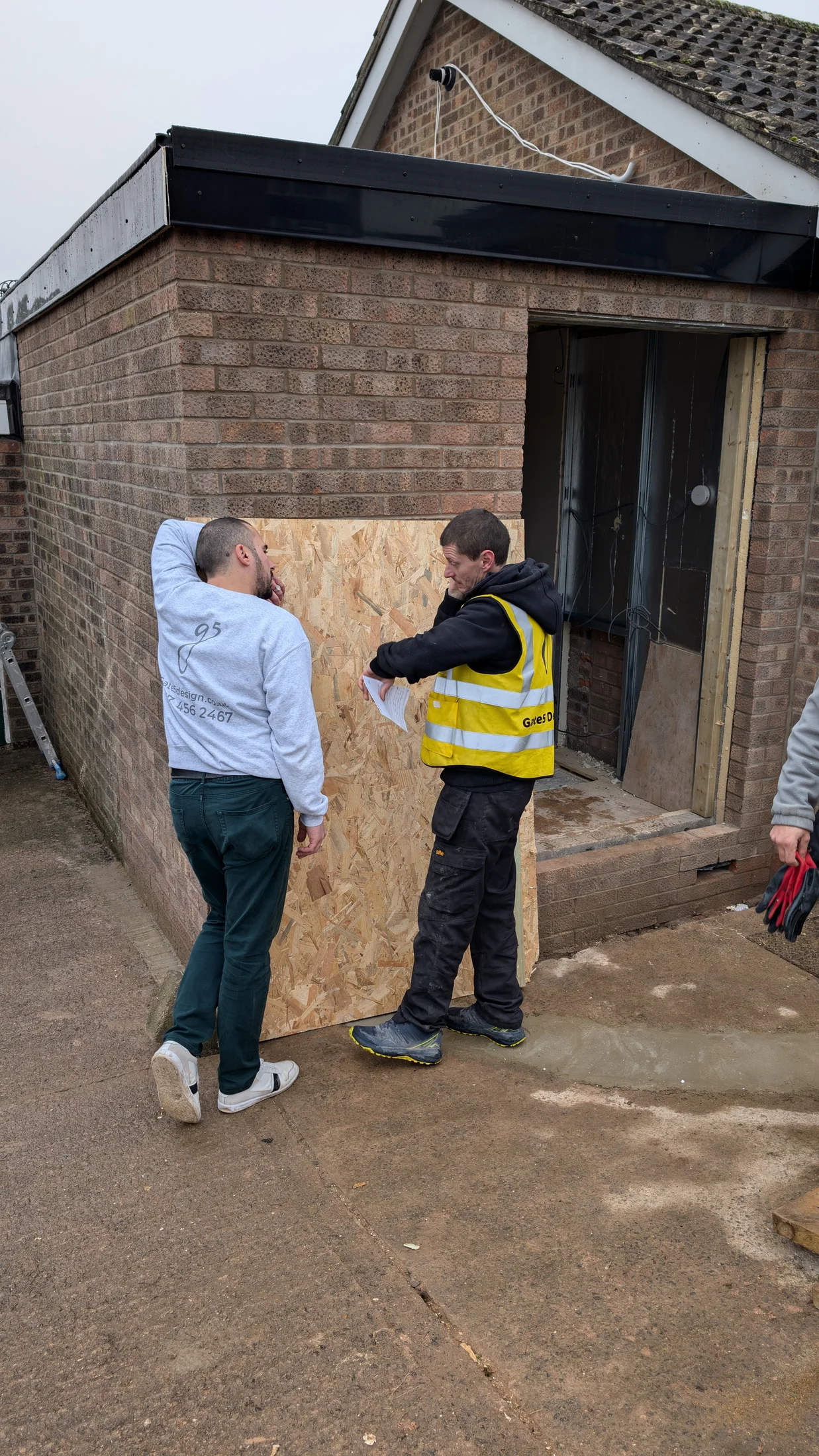 Gate5 team and client discussing the garage exterior in Chepstow