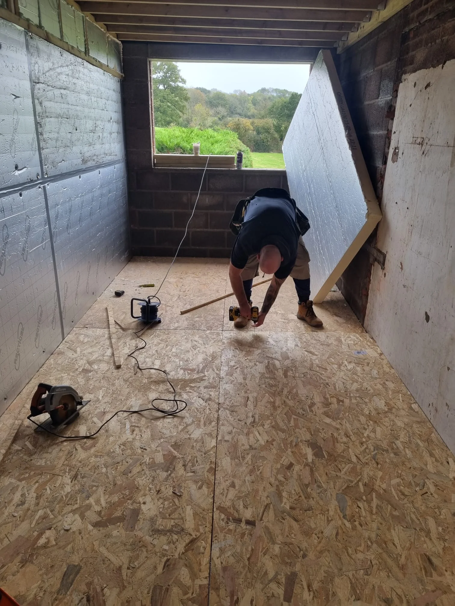 Contractor preparing the timber floor deck inside the converted garage