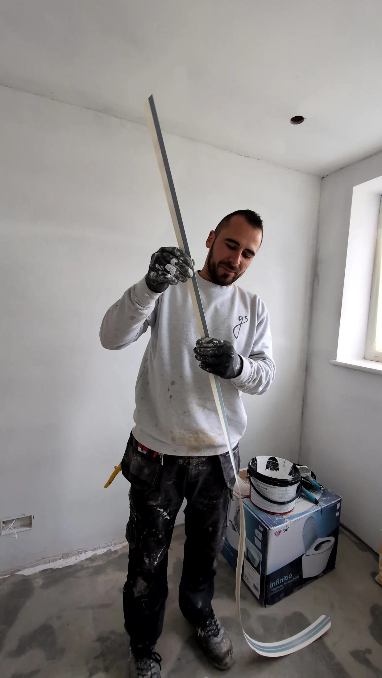 Contractor finishing the white ceiling and wall surfaces