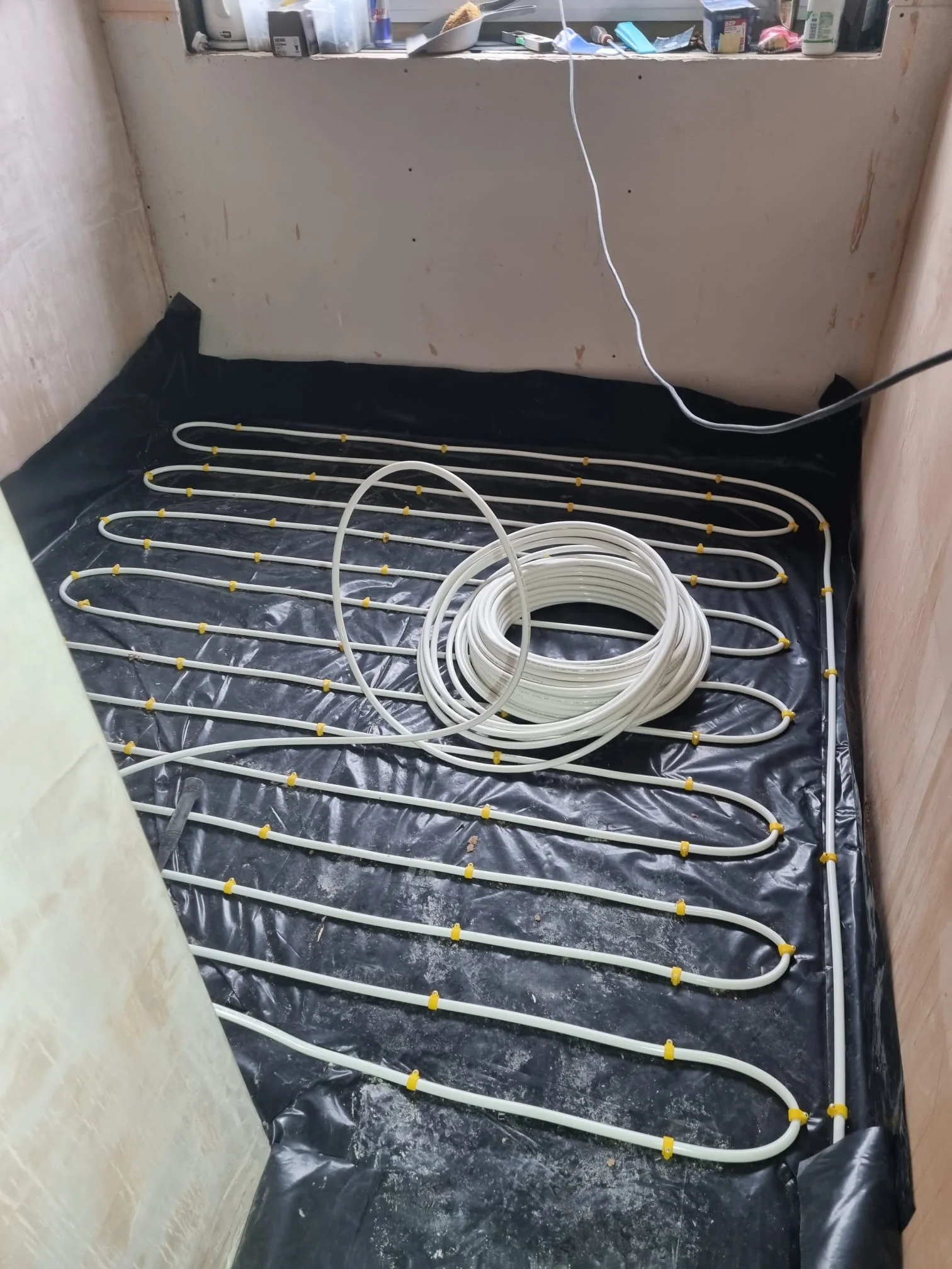Underfloor heating pipework installed in the converted garage