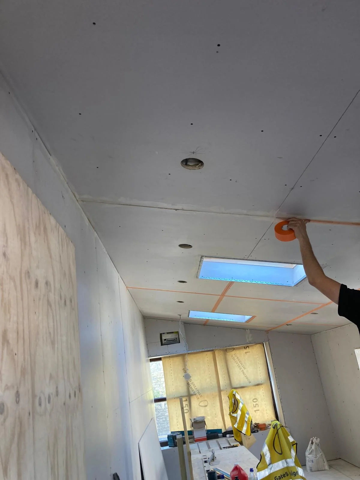 Ceiling plasterboard fitted along the room
