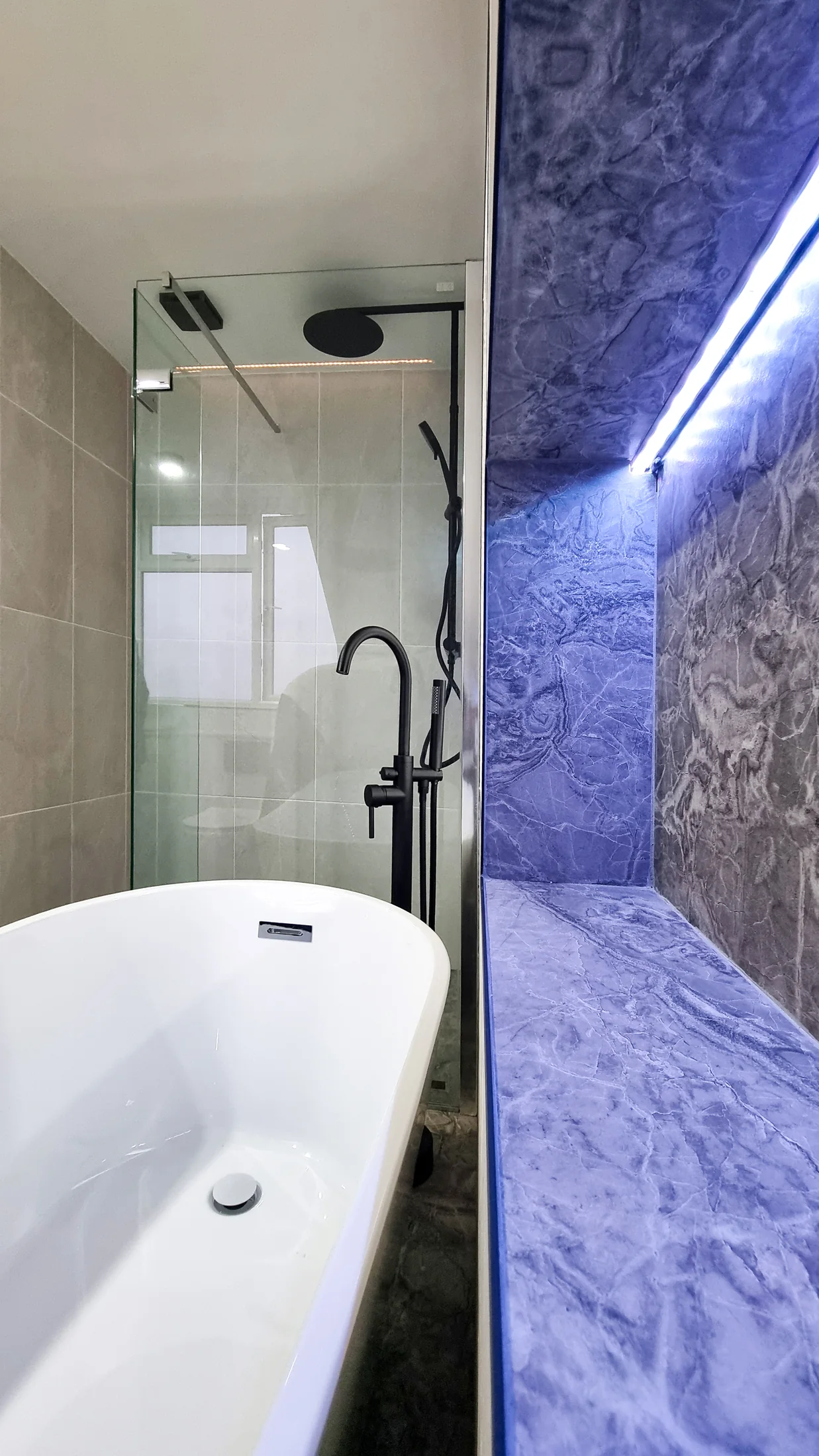 Freestanding bath, shower and illuminated stone recess