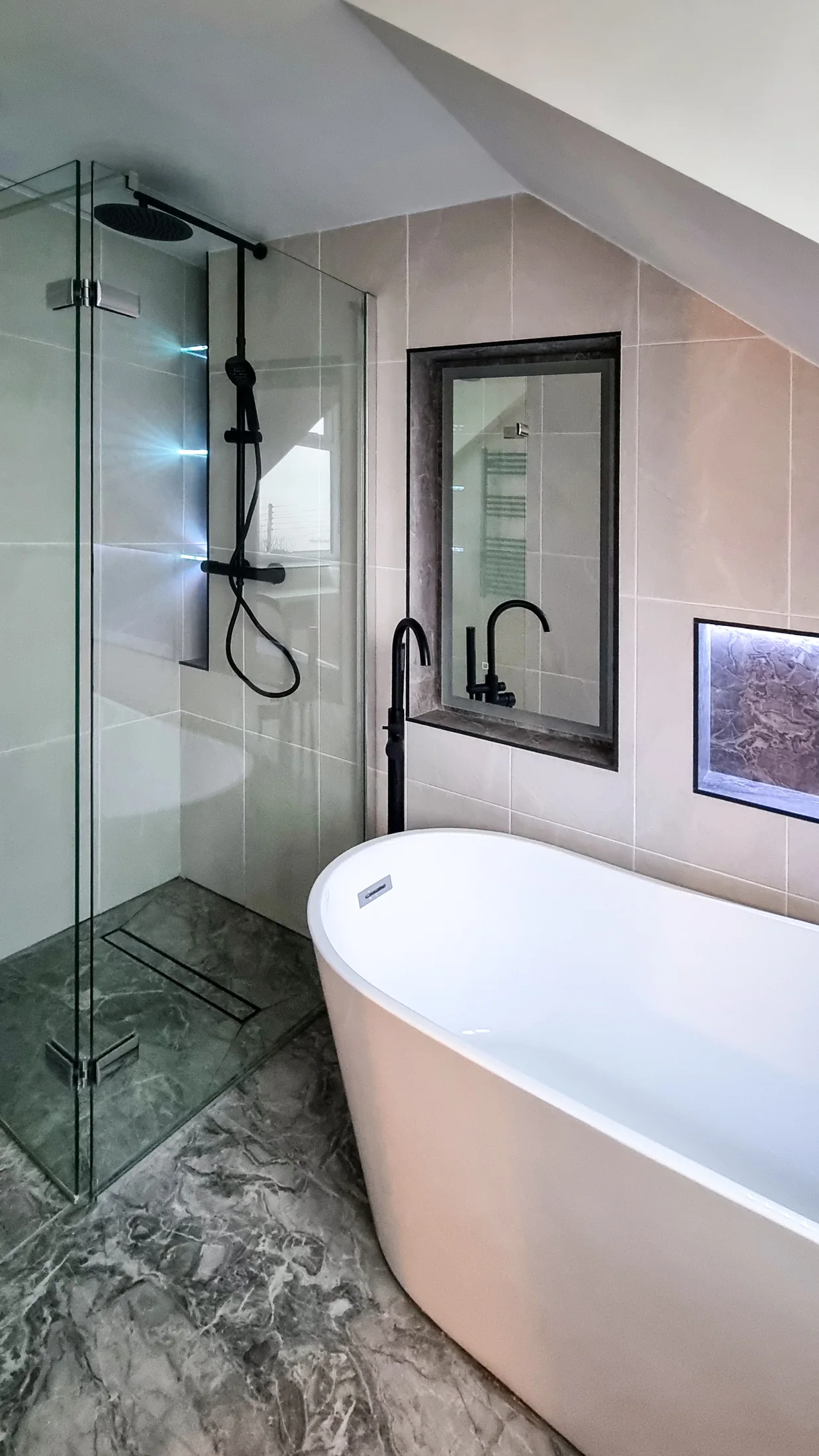 Freestanding bath, frameless shower and black fittings in the completed light bathroom
