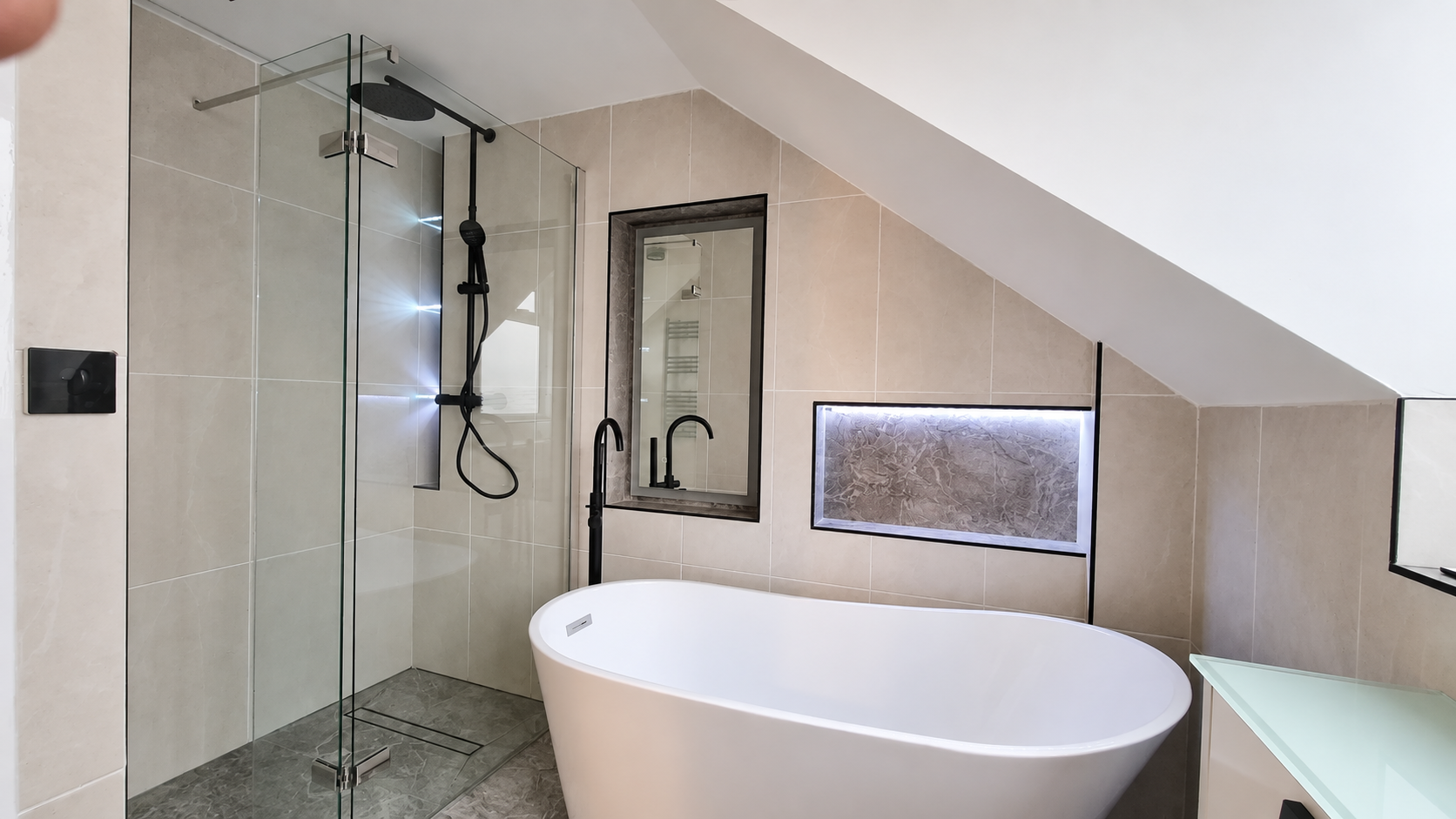 Completed light bathroom with freestanding bath and illuminated wall recess