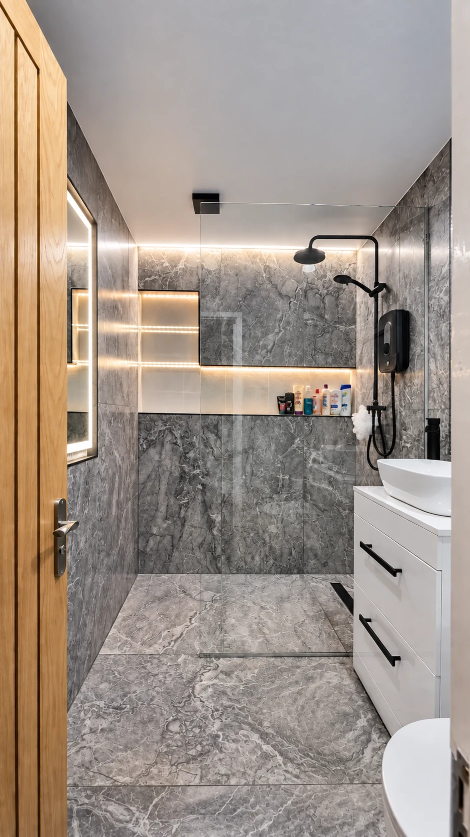 Completed marble-effect en-suite with illuminated mirror, integrated lighting, walk-in shower and white vanity