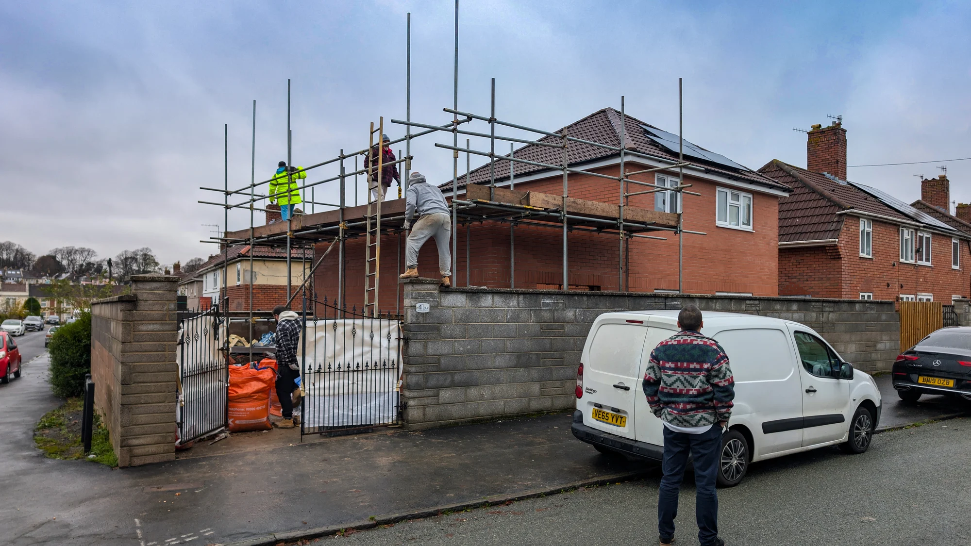Residential extension construction with scaffolding and site team